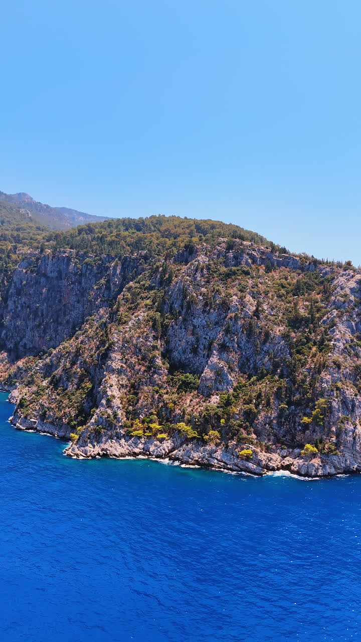 Stunning coastal cliffs by the blue sea. Serene view of breathtaking cliffs meeting turquoise waters under a clear blue sky in a coastal region