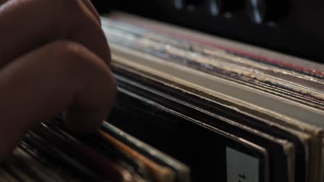 close up man hands browsing vintage vinyl records at home