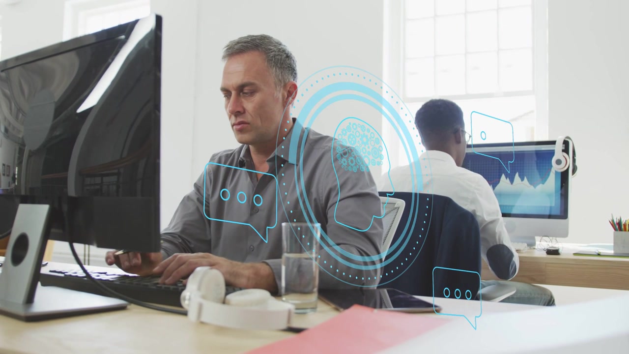 Man typing in tech office, causing HUD rings as colleague approaching pointing at chart for review