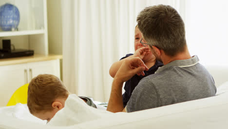 Father-consoling-his-crying-baby-on-sofa-4k