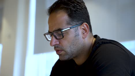 una persona se sienta en el interior, mirando con curiosidad su teléfono móvil