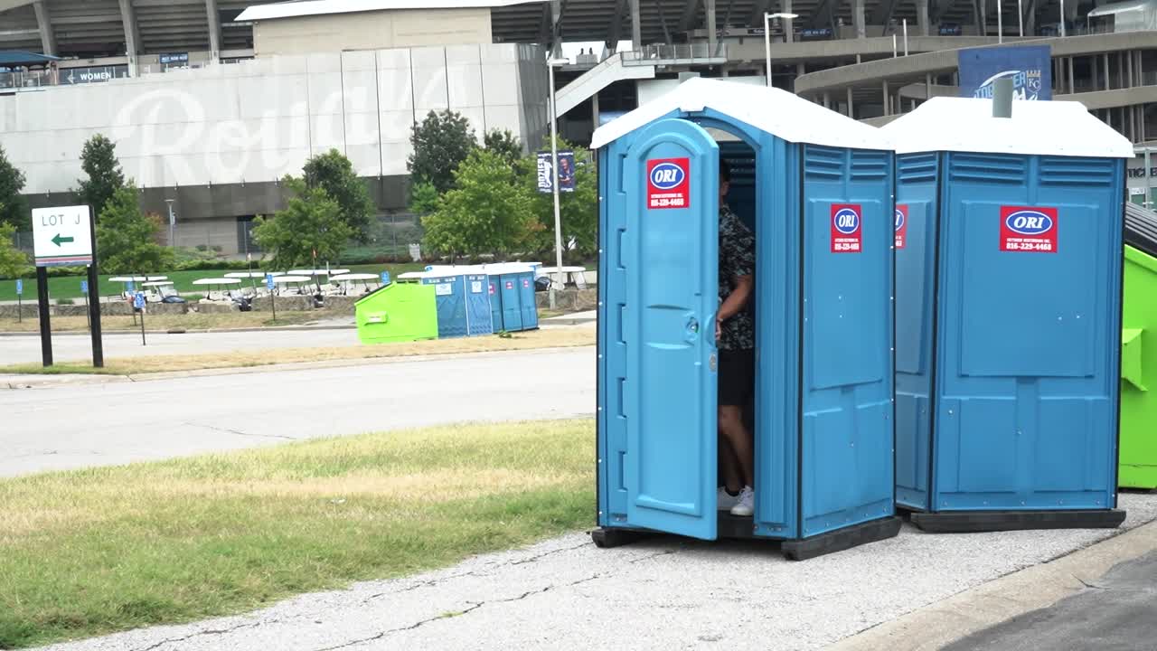 un hombre entra en un baño portátil