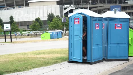 man walks into a porta-potty