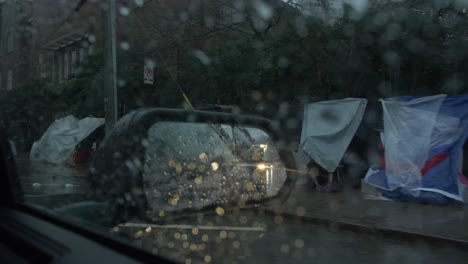 homeless tents in rear view mirror rain downtown atlanta slow motion