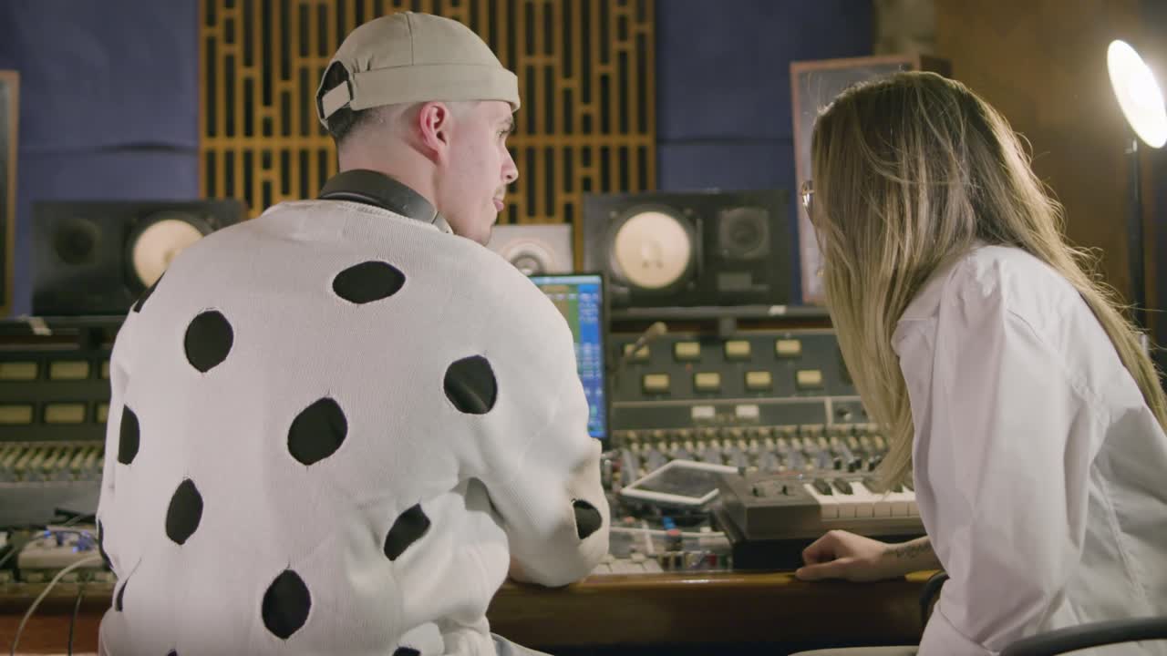 새로운 노래를 녹음하는 동안 음악 스튜디오에서 일하는 두 명의 음악가