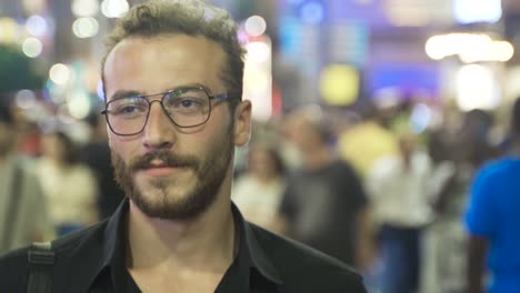 young man walking through the night crowd.