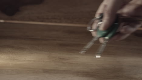 Hand-picks-up-and-sets-ring-of-three-keys-on-wooden-table,-close-up-slow-motion