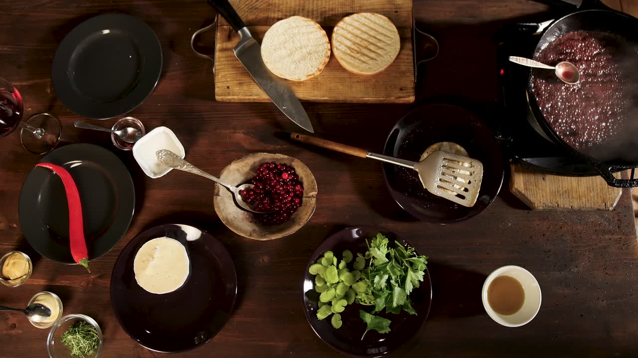 Preparing a delicious meal with burger, cranberries, and cheese