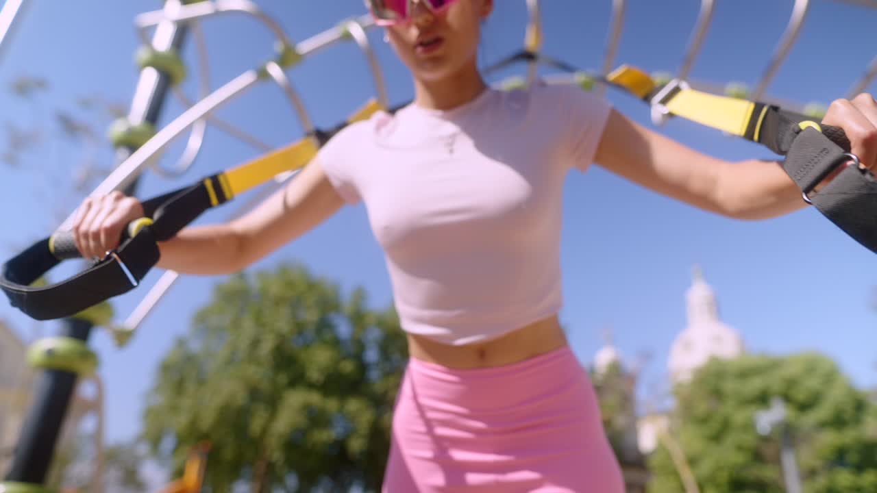 Woman Exercising with Suspension Trainer Outdoors