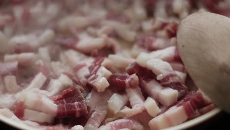sizzling goodness: slow motion close-up of pancetta and guanciale strips cooking for carbonara. italian cuisine