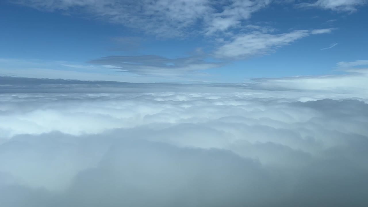 vista piloto sobrevolando un mar de nubes blancas, luz del día