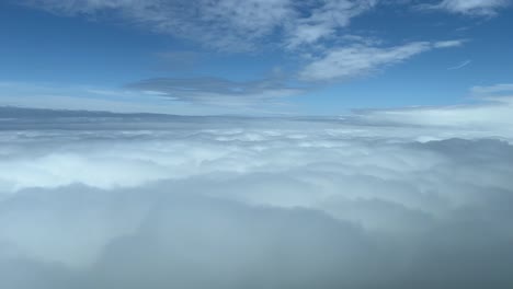 Pilot-view-overflying-a-sea-of-white-clouds,-daylight