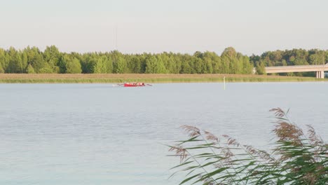 Gruppe-Von-Menschen,-Die-Ein-Großes-Boot-In-Der-Nähe-Der-Küste-Rudern