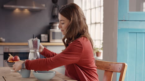 mujer vertiendo café en el desayuno usando teléfono inteligente en la cocina en casa