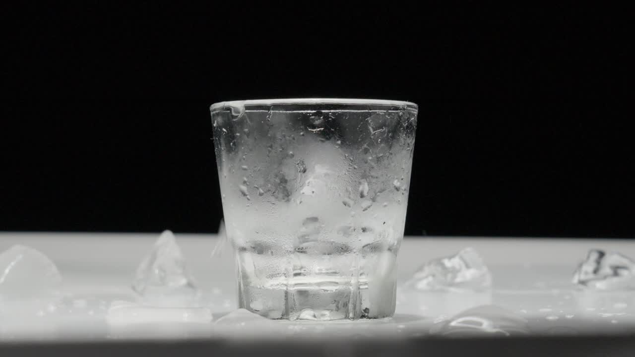 얼어붙은 얼음이  테이블에 은 유리잔에 떨어지는