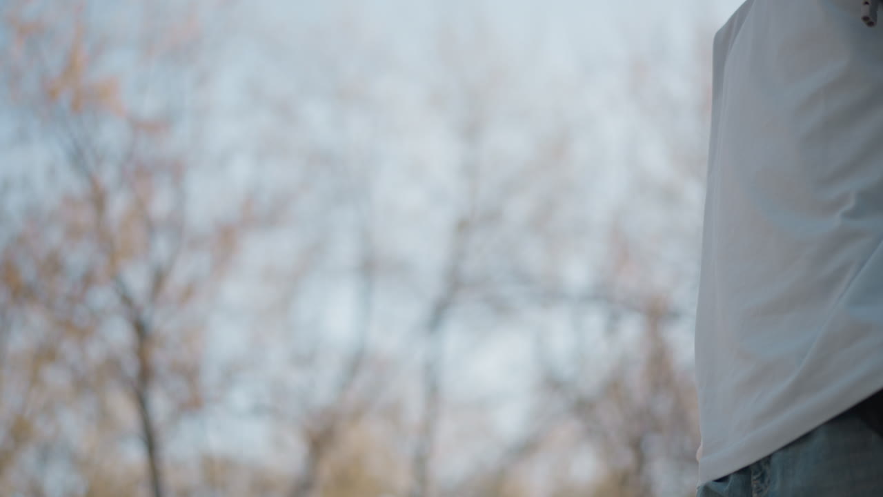 세련된 액세서리를 선보이는 인플루언서, 트렌디한 검은색 가방을 들고 야외에서 포즈를 취하는 사람, 흐릿한 배경과 생동감 넘치는 분위기 속에서 현대적인 액세서리를 모델처럼 소화하는 개인