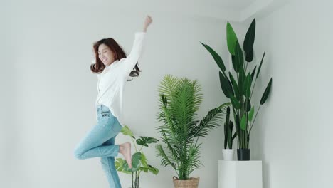 Mujer-Sonriente-En-Cámara-Lenta-Y-Camisa-Blanca-Bailando-Con-Buena-Emoción-En-La-Habitación-Blanca