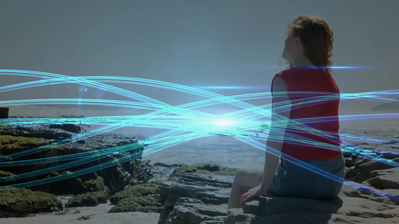 Woman sitting on ledge viewing blue light bands appearing, converging on horizon showing tech flow