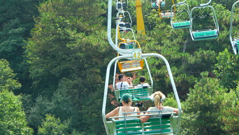 mother and daughter riding the chairlift up to the mutianyu chinese wall. slow motion