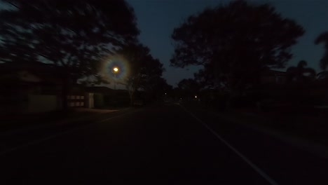 rear facing night driving point of view pov for interior car scene green screen replacement - a quiet and narrow suburban street with trees and right hand bend