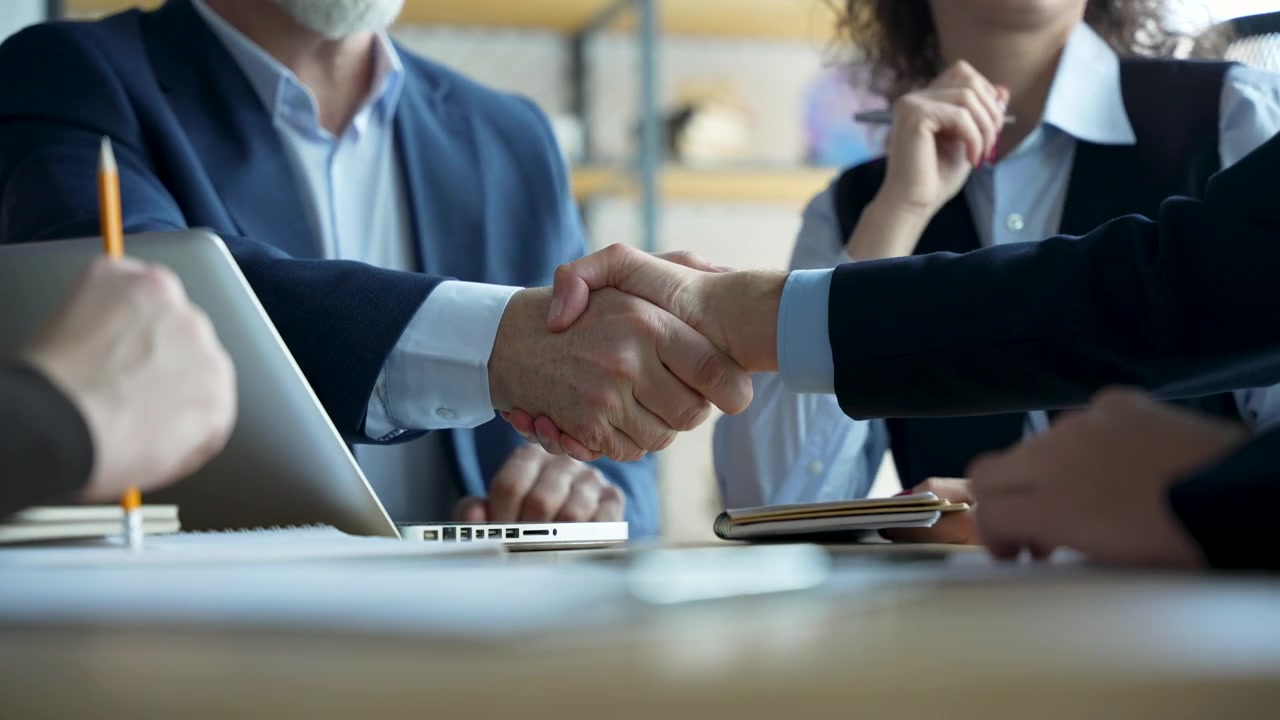 Professionisti d'affari che si stringono la mano durante una riunione in ufficio