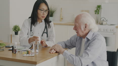 doctor giving medication to elderly patient at home