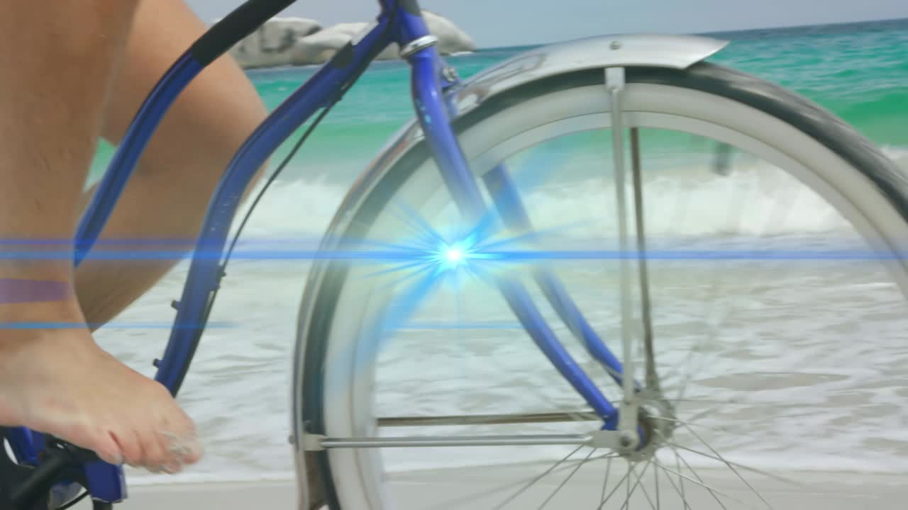 해변에서 자전거를 타고 있는 남자의 벌거벗은 발 위로 움직이는 파란 빛 의 애니메이션
