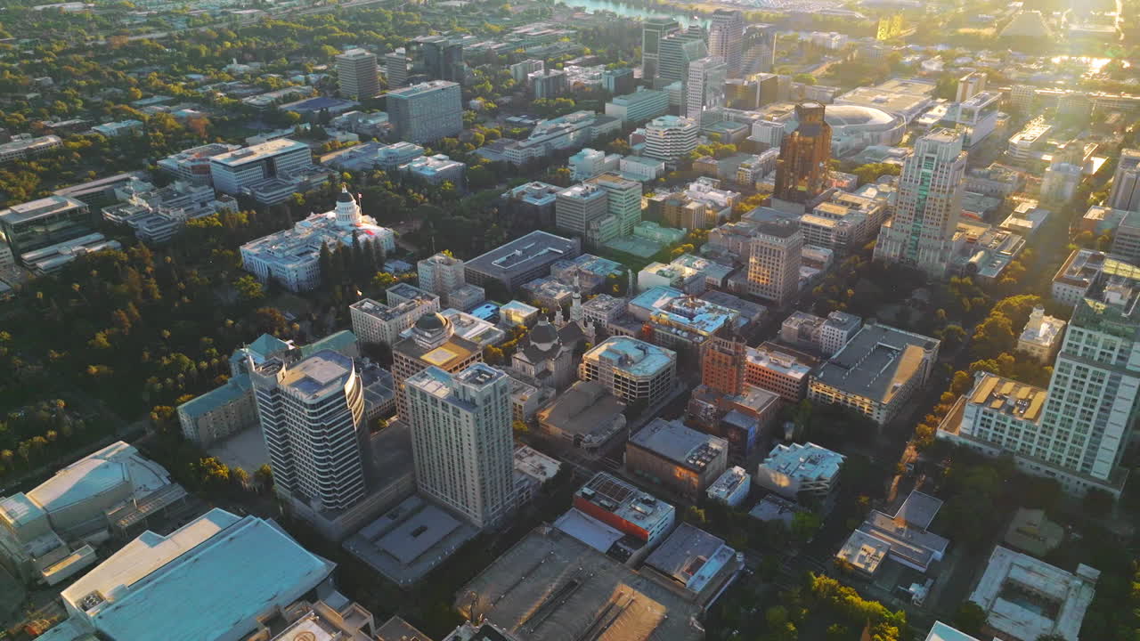 Contemporary urban architecture with lots of greenery. Amazing Sacramento city in the rays of setting sun from aerial view.