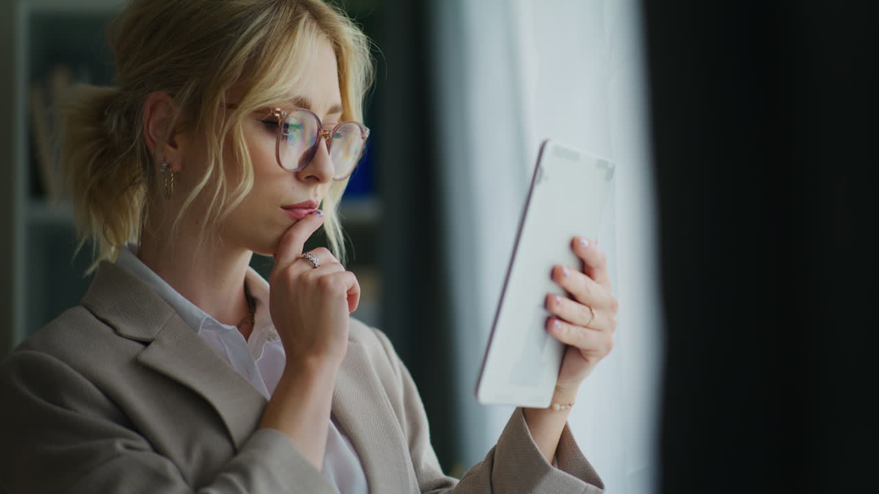 Concentrated Businesswoman Analyzes Financial Results on Tablet