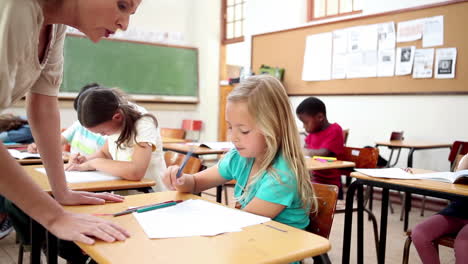 teacher helping a blonde pupil