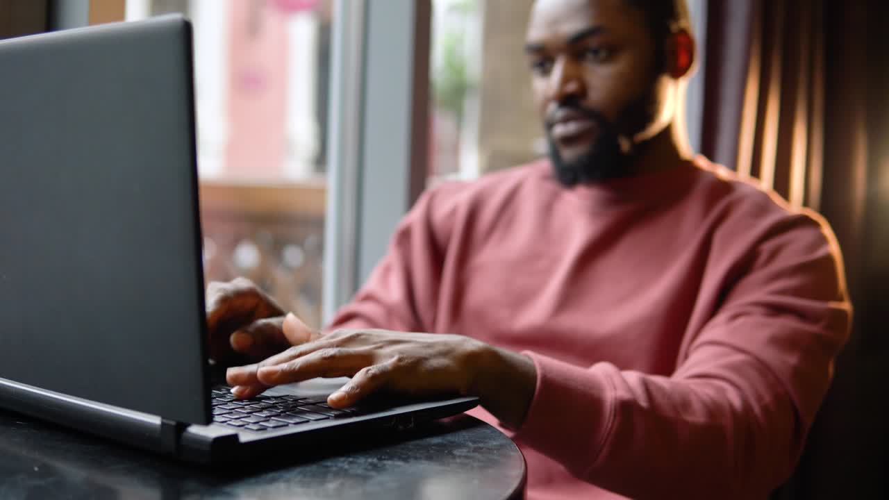 Man working with the laptop in the restaurant. Freelance work from cafe
