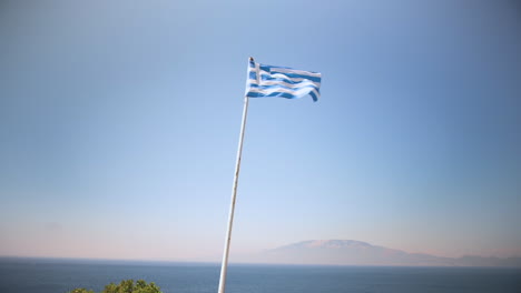 Nationalflagge-Griechenlands-Weht-Im-Wind-Mit-Einem-Schönen-Blick-Auf-Einen-Blauen-Und-Orangefarbenen-Himmel