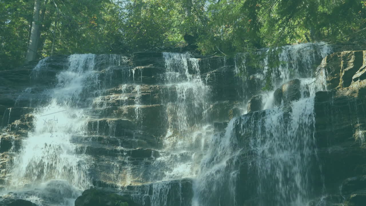 Waterfall cascading over rocky cliff with lush green trees surrounding it