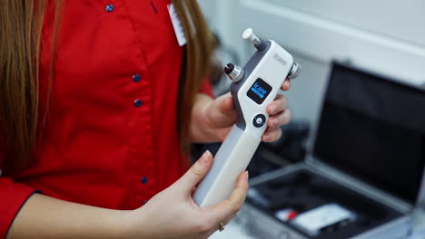 modern device for eye checking. optical tool in doctor's hands. female ophthalmologist holding medical instrument in clinic.