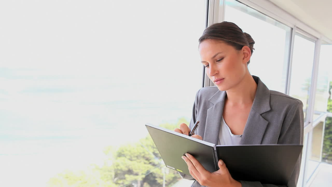 mujer de negocios escribiendo en un archivo
