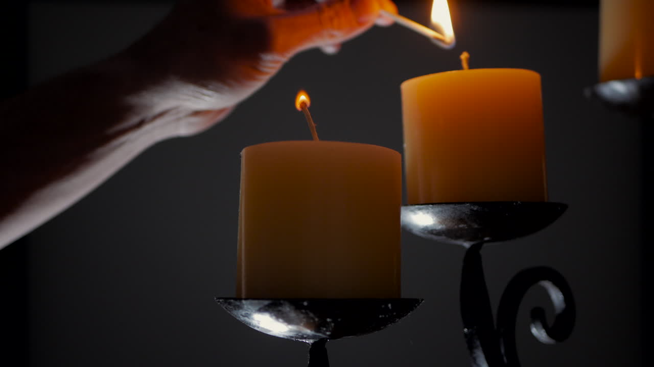 Uomo che accende candele su un candelabro ornamentale