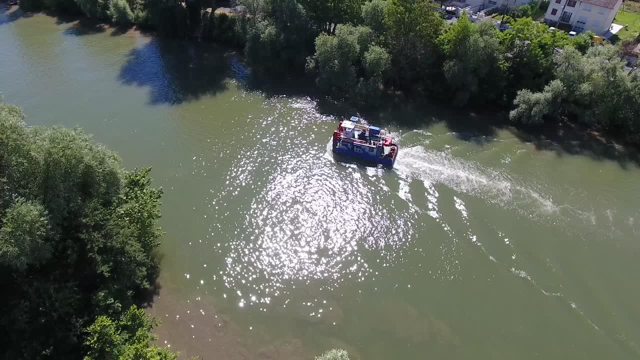 Ripresa con drone che segue un rimorchiatore su un fiume in Francia. Giornata di sole