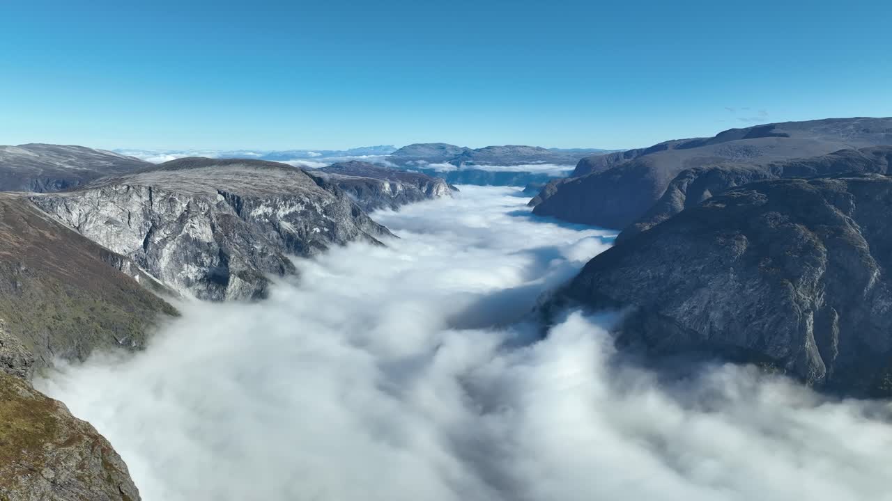 Drone reverses quickly over fjord and mountains, surprising the viewer as Bakkanosi rocks appear in the foreground
