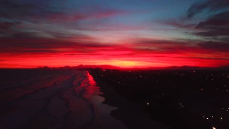estableciendo una foto aérea lenta de la puesta de sol de la tarde en la playa del océano de itanhaem, cielo de colores locos en brasil