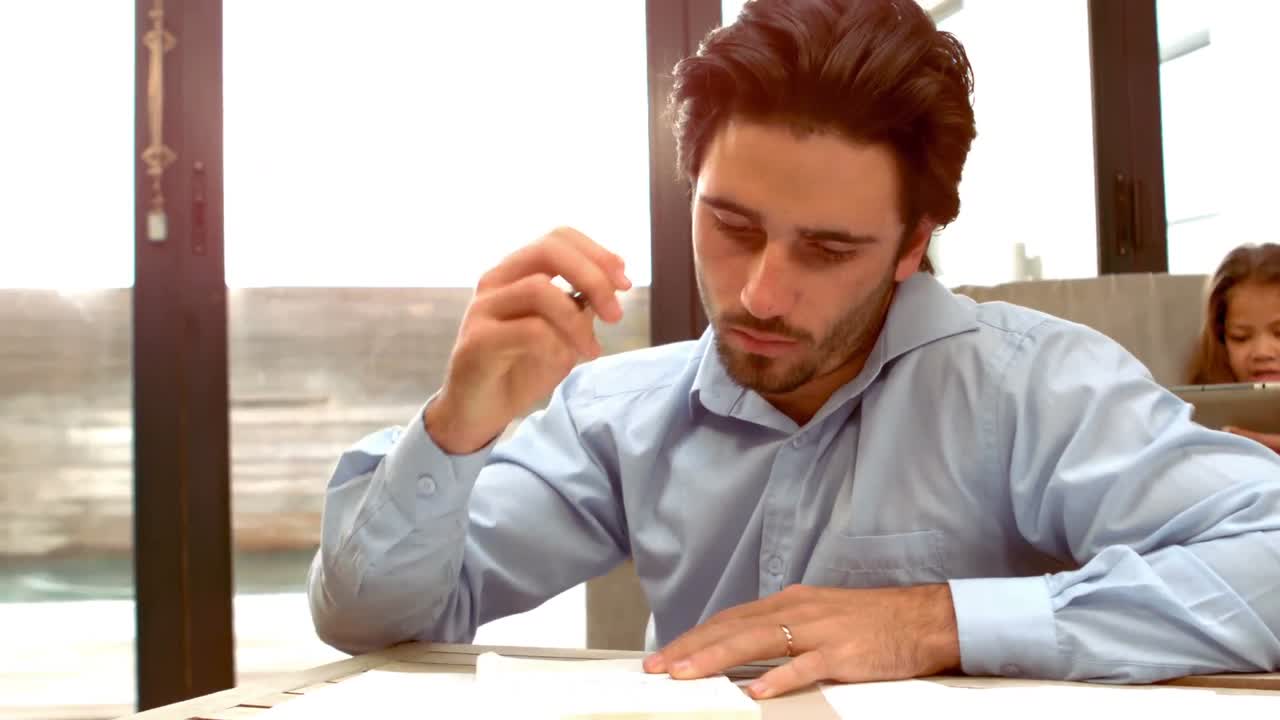 испанский мужчина работает, в то время как его жена и дочь в на диване