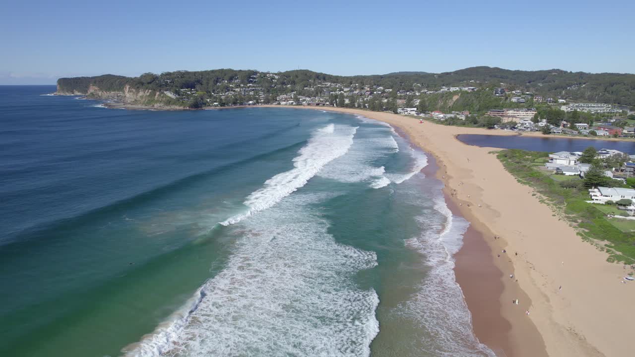 vista aérea de los bañistas caminando en la playa de avoca con el lago avoca en la costa central, nsw, australia