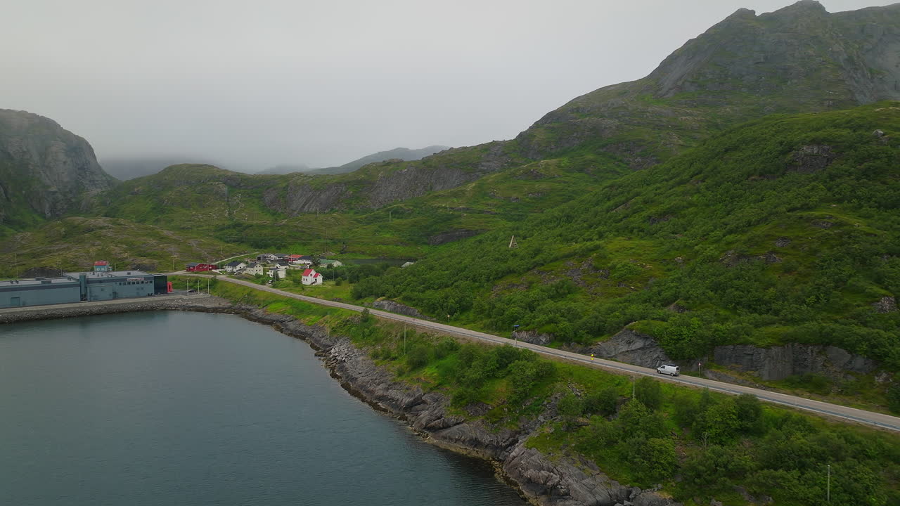 campervan conduciendo en la carretera en un islote brumoso de islendingen en nordland, lofoten, noruega