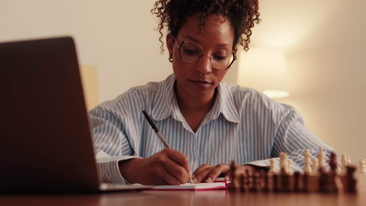 Woman Strategizing With Chessboard at Desk