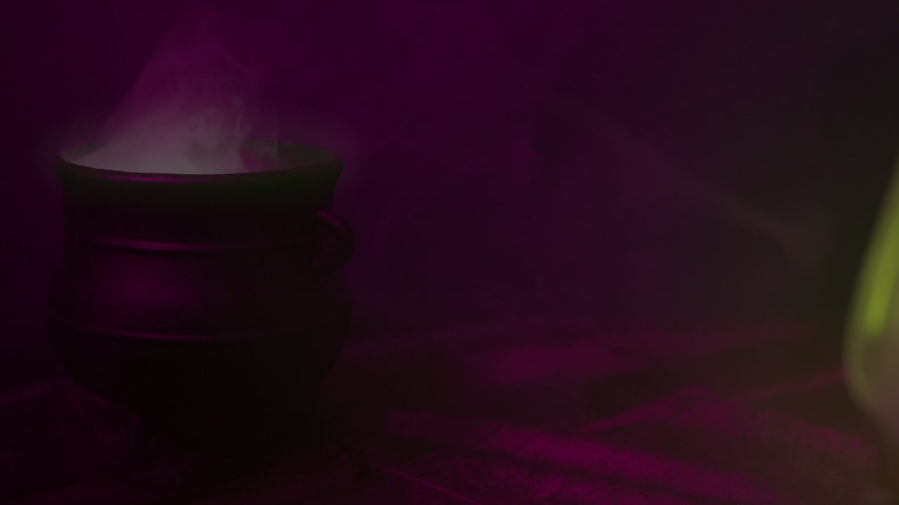 Halloween-noitien pata, jossa kiehuu savuava juoma ja tilaa otsikkografiikalle.