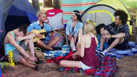 friends playing guitar and having drinks at music festival 4k