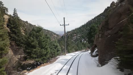 manitou and pikes peak cog railway through snowy mountain pass in colorado, usa. pov, pullback shot