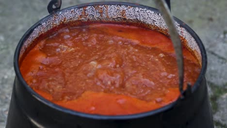 Cooking-stew-in-the-open-air-that-slowly-cooks,-Croatia,-Čobanac,-Traditional-meal,-Slavonia