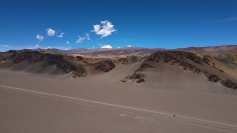 drone shot flying over a plateau towards the andes mountains in the desert in catamarca, argentina