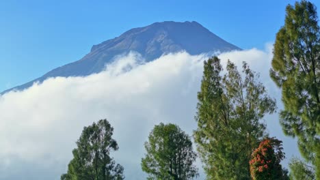 clouds flowing bellow mount sumbing peak in indonesia, static view