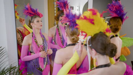 female dancer helping each other to get ready for the show while talk and smile